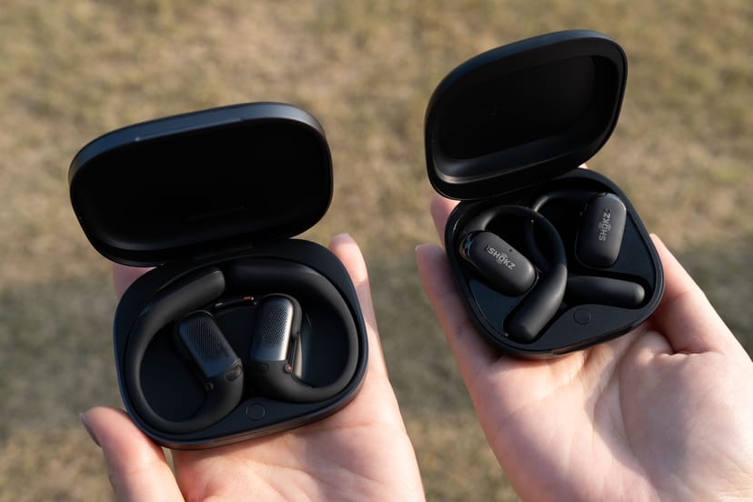 OpenFit Pro（左）とOpenFit 2（右）の充電ケースを手に持って比較