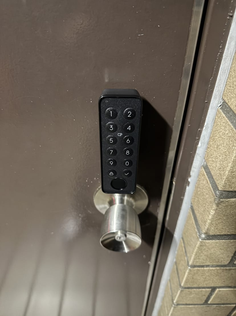 ドア外側に設置した指紋認証パッド。テンキーの数字ボタンと丸ノブが並んでいる