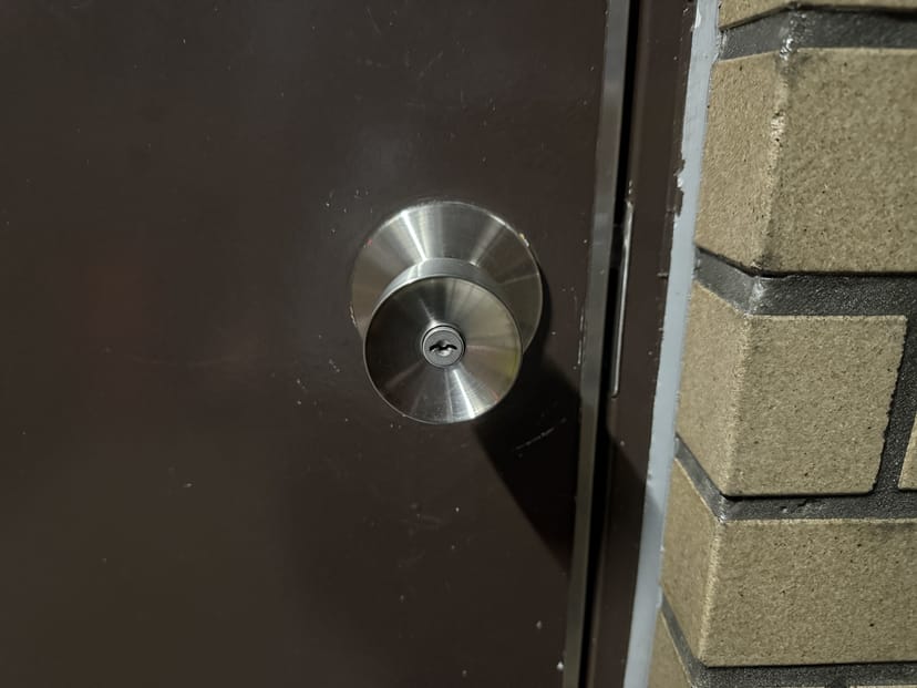 玄関ドア外側の丸ノブ。銀色の円形ノブと鍵穴が見える